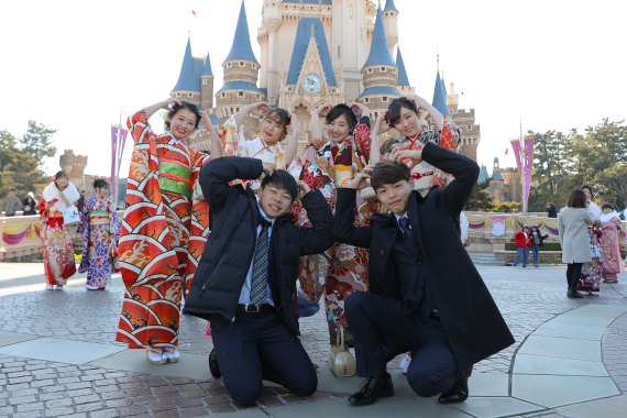 ('At Tokyo Disneyland in Chiba Prefecture, Japan, young people dressed in formal attire take photos in front of the castle. Information from Xinhua News Agency',)