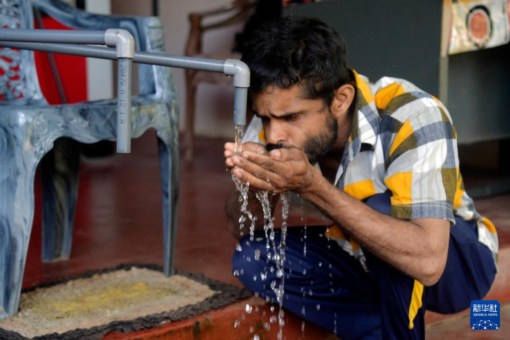 On October 2nd, villagers were drinking water in front of a Chinese assisted drinking water facility in Nidiya Village, central northern Sri Lanka. Xinhua News Agency (Photo by Jia Yang Samira)