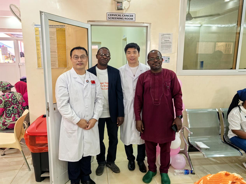 Chinese medical team gynecological expert Cai Guiyang, general surgery expert Wei Fang, and director of obstetrics and gynecology at Edward Francis Small Teaching Hospital Abdouli Keita and obstetrician Egu took a photo in front of the cervical cancer screening clinic. (Image provided by the Chinese medical team aiding Gambia)