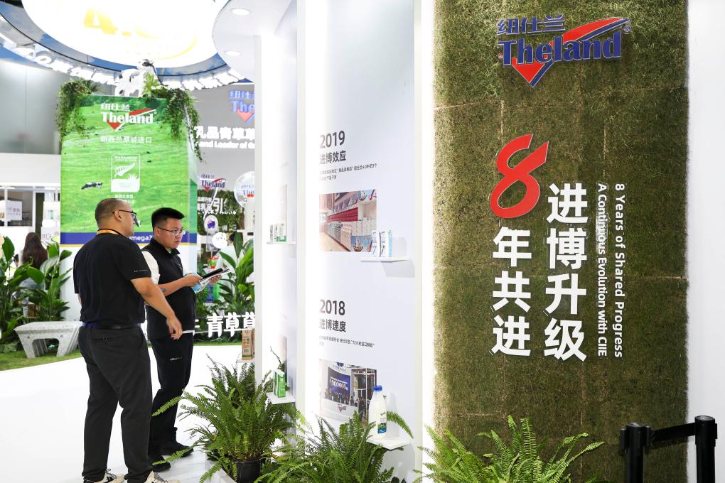 On November 7th, the exhibitor (left) introduced New Zealand dairy products to visitors. Photo by Xinhua News Agency reporter Wang Xiang