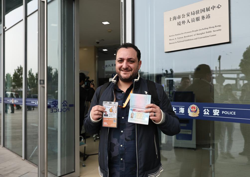 On November 7th, at the Overseas Personnel Service Station of the Shanghai Public Security Bureau's National Exhibition Center, Mohammad Baghdashi, an exhibitor from Syria, showcased his extended visa at the CIIE. Photo by Xinhua News Agency reporter Fang Zhe