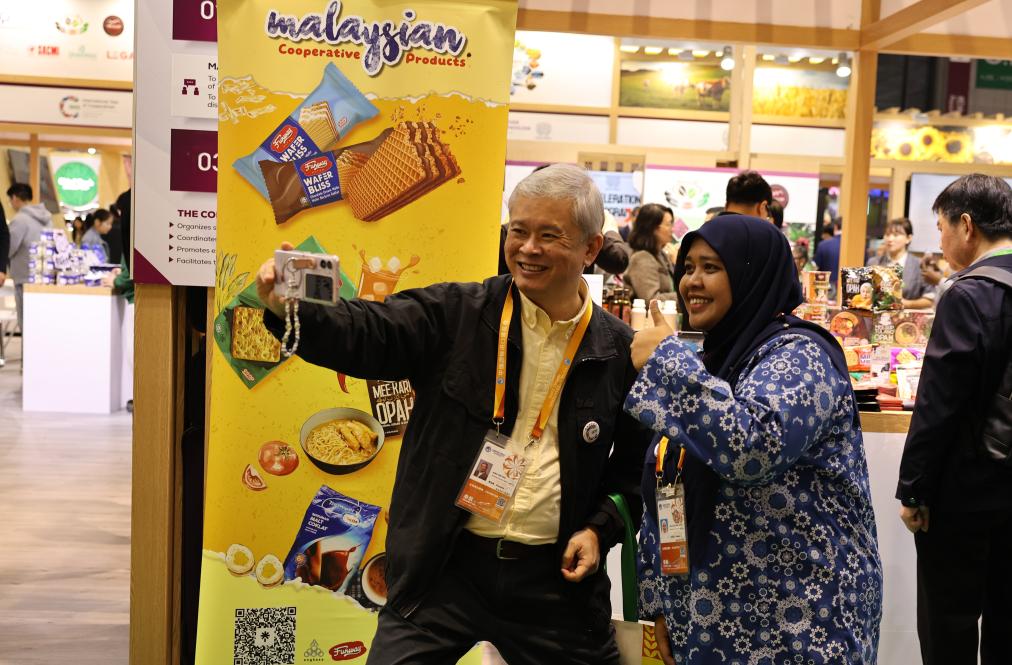 On November 7th, at the 8th CIIE Agricultural and Food Products Exhibition Area, Singaporean exhibitors (left) and Malaysian exhibitors took a group photo. Photo by Xinhua News Agency reporter Fang Zhe