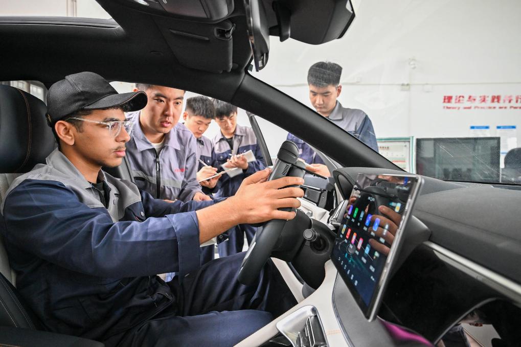 On June 27, 2025, at the Automotive Engineering College Training Center of Tianjin Transportation Vocational College, Guo Zhenkai (left) operated a fault diagnosis instrument under the guidance of teacher Zhou Fan to troubleshoot vehicle faults. Recently, the first batch of Egyptian Luban Workshop international students graduated from Tianjin Transportation Vocational College. Guo Zhenkai, a 20-year-old youth from Cairo, Egypt, successfully obtained his first graduation certificate in China. Photo by Xinhua News Agency reporter Sun Fanyue