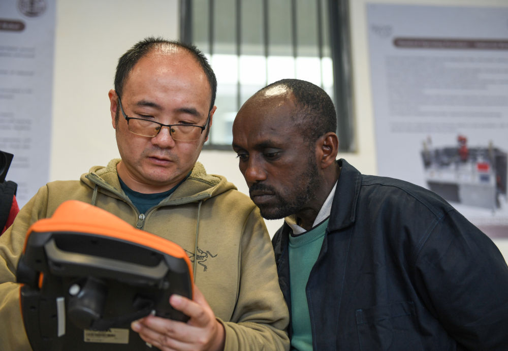 On February 15, 2024, at the Ethiopian Federal Vocational and Technical Training Institute in Addis Ababa, Jiang Jiang (left), the Chinese leader of the Luban Workshop, exchanged teaching content with local teacher Jonas Akale (Chinese name Ai Youhan). (Photo by Li Yahui)