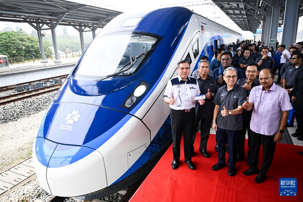 On February 11th, in Pahang, Malaysia, guests took a group photo in front of a high-speed train. Photo by Cheng Yiheng, Xinhua News Agency reporter
