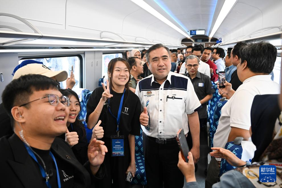 On February 11th, in Pahang, Malaysia, Malaysian Minister of Transport, Lu Zhaofu (center right), took a photo with the staff while visiting a high-speed train. Photo by Cheng Yiheng, Xinhua News Agency reporter